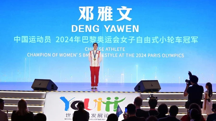 Deng Yawen, an 18-year-old gold medalist of Cycling BMX Freestyle at the Paris 2024 Olympic Games, speaks during the opening ceremony of the 2024 World Youth Development Forum in Beijing, Aug. 12, 2024. 