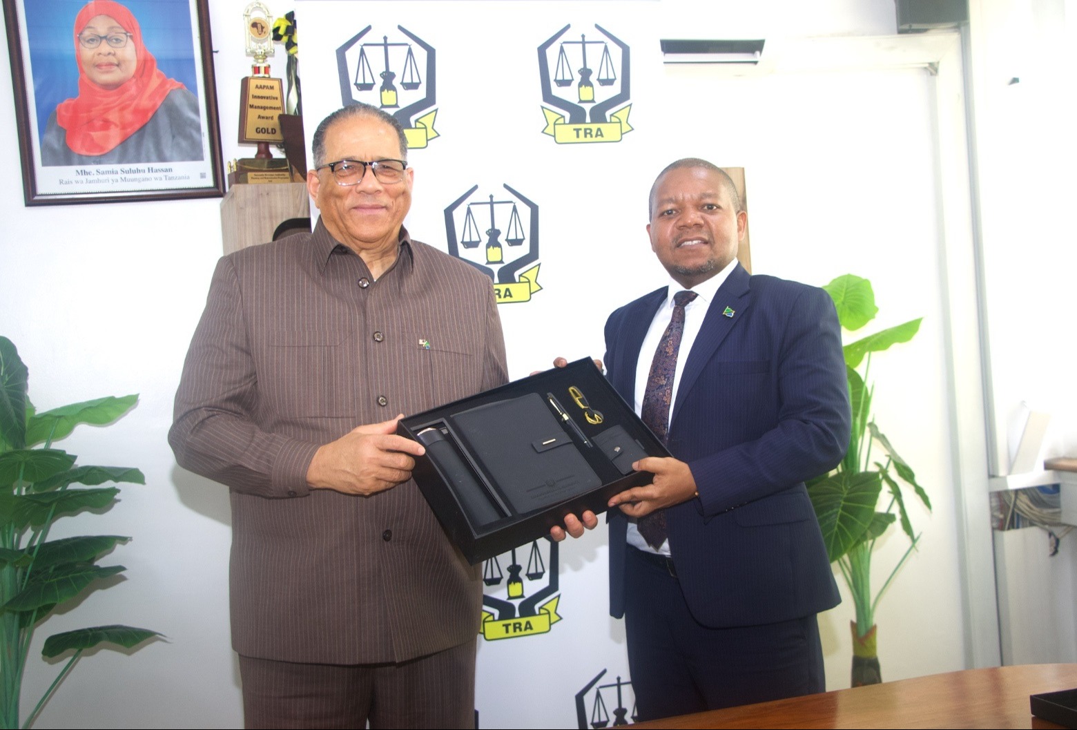 Tanzania Revenue Authority commissioner general Yusuf Mwenda (R) presents a gift to the US Ambassador to Tanzania, Michael Battle, after talks at the TRA headquarters in Dar es Salaam on Thursday. 