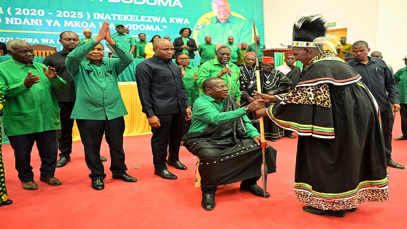 A representative of Dodoma Region tribal chiefs and elders presents a traditional spear to Vice President Dr Philip Mpango, who is also a member of CCM Central Committee member 