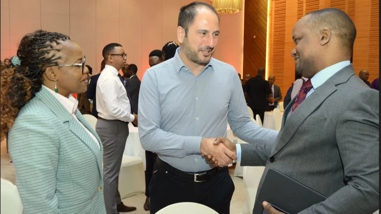 Absa Bank Tanzania Managing Director, Obedi Laiser (R), shakes hands with Yapi Merkezi Head of Finance, Levent Doruk (C ), during the bank’s corporate clients meeting to showcase the bank’s latest digital solutions designated to empower businesses in Tanz