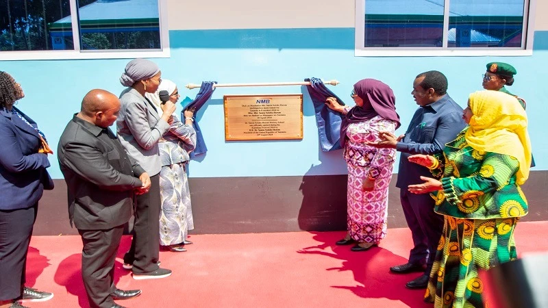 President Samia Suluhu Hassan (C) opening the curtain to launch the Dr Samia Suluhu Hassan preparatory school located in Makunduchi in the Unguja South Region yesterday, built by NMB Bank