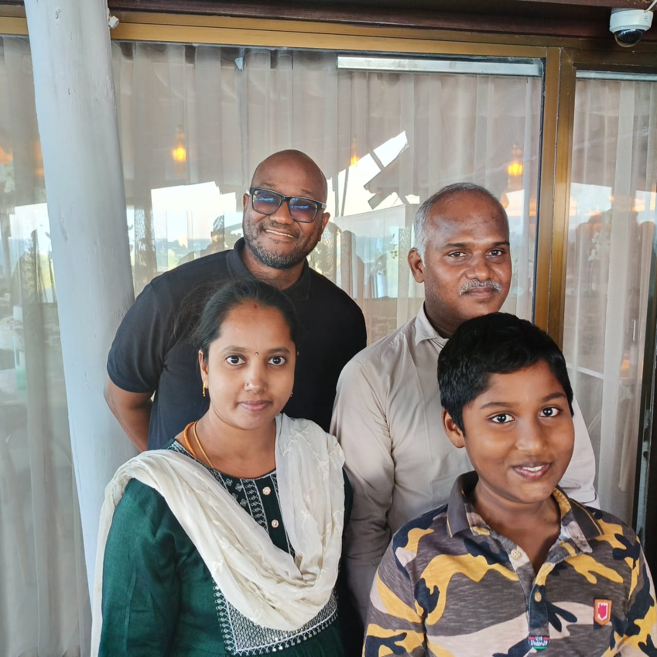 8.	IPP Executive Chairman Abdiel Mengi poses in a group photo with former TGL operations manager Murugan Vajran and his family. 