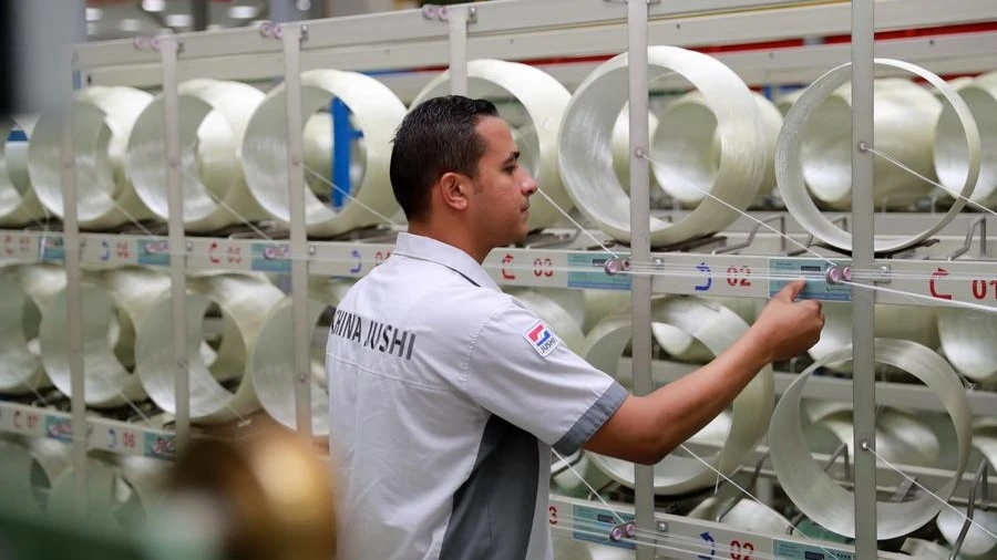 Ahmed Soliman, deputy general manager of Jushi Egypt Fiberglass Co., Ltd., checks on the fiberglass production line of Jushi Egypt at the China-Egypt TEDA Suez Economic and Trade Cooperation Zone in Suez province, Egypt, Aug. 10, 2023. 