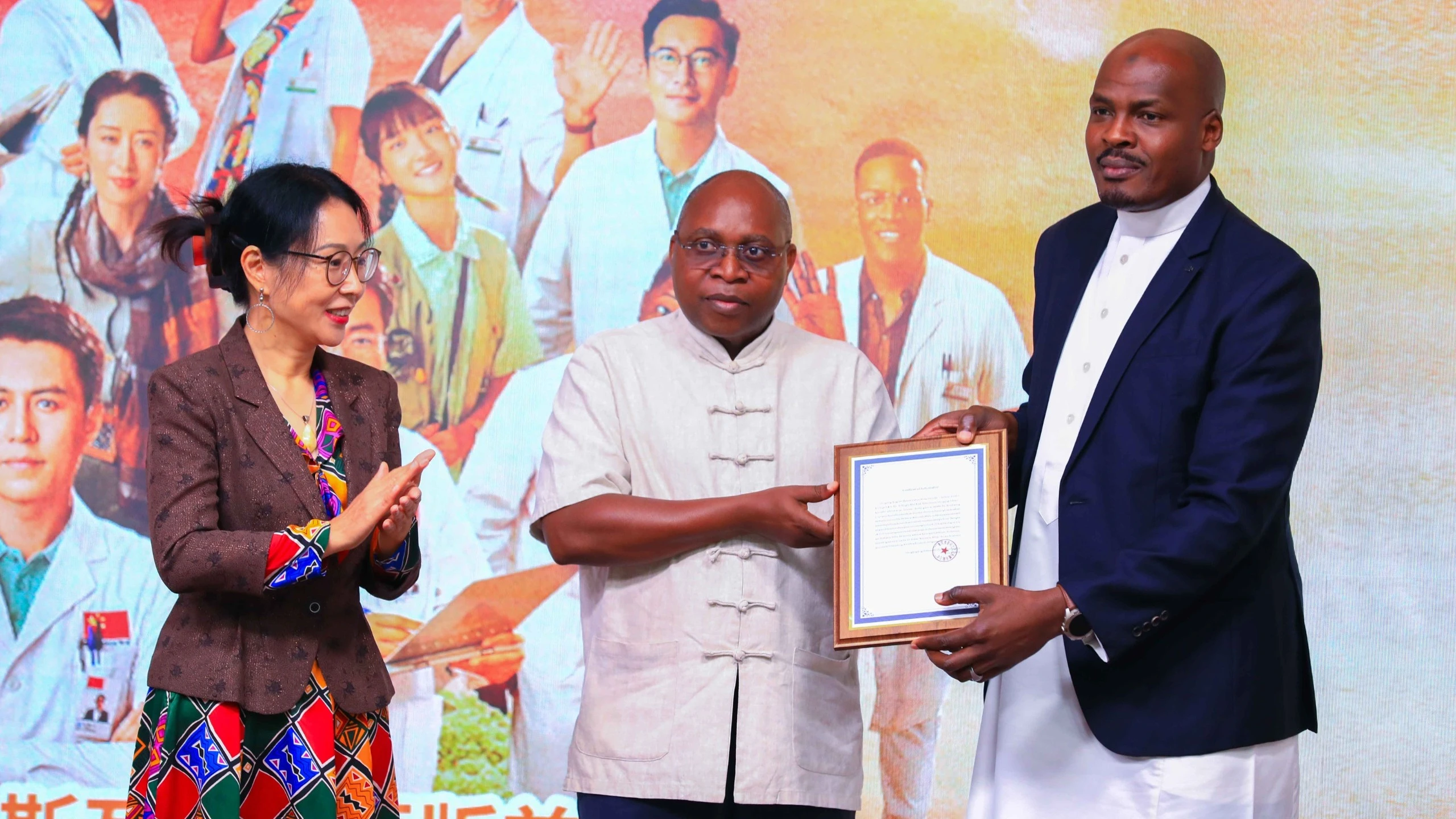 
Yahya Mohammed (R), CEO of Azam Television, presents the launch certificate for the television series Welcome to Milele to Dr. Damas Ndumbaro, Tanzania’s Minister of Culture, Arts, and Sports (C). 