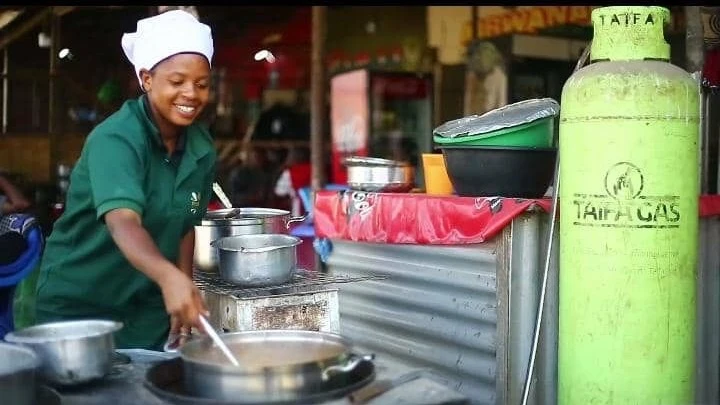 One of the small food business owners at the Msamvu market in Morogoro, Ms. Halima Kimairo, who is one of the beneficiaries of a 50 cooking gas cylinders credit program from Taifa Gas company, continues with her business activities in the market towards