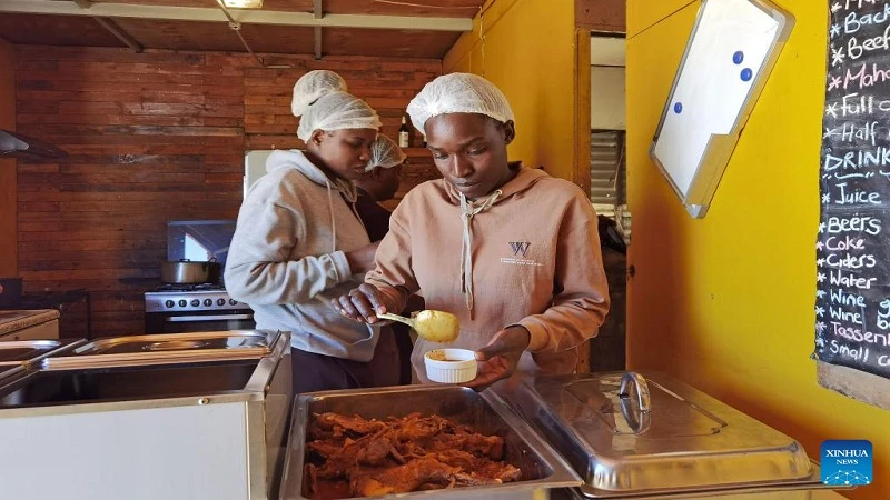 An employee serves traditional dish at Sai's Kitchen, an eatery in the informal settlement popularly known as Havana, in Windhoek, Namibia

