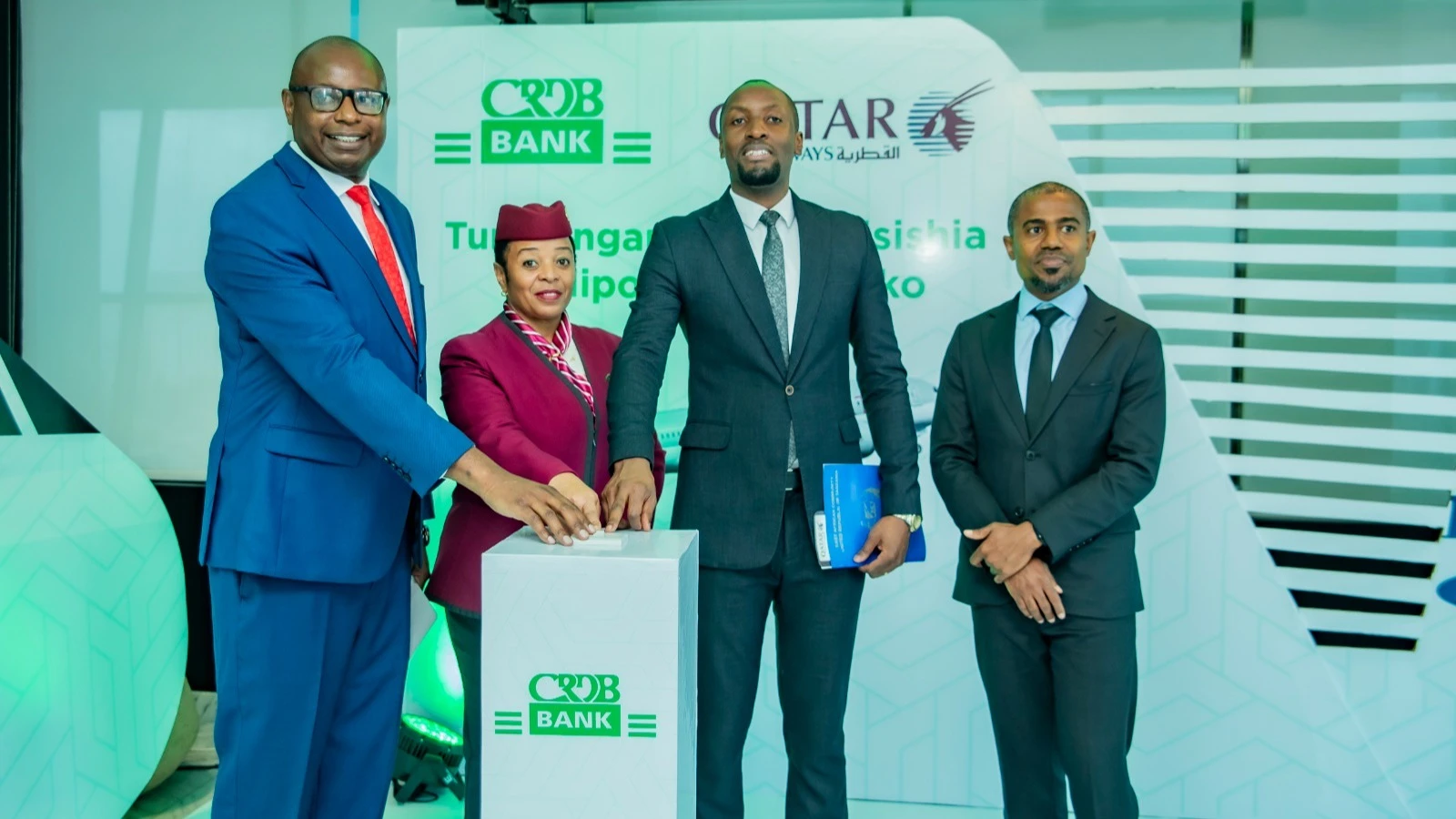 Muhumuliza Buberwa, the acting retail and intermediate banking director , CRDB Bank (2nd  R), along with the Qatar Airways Resident Manager, Isaack Wambua (L), 