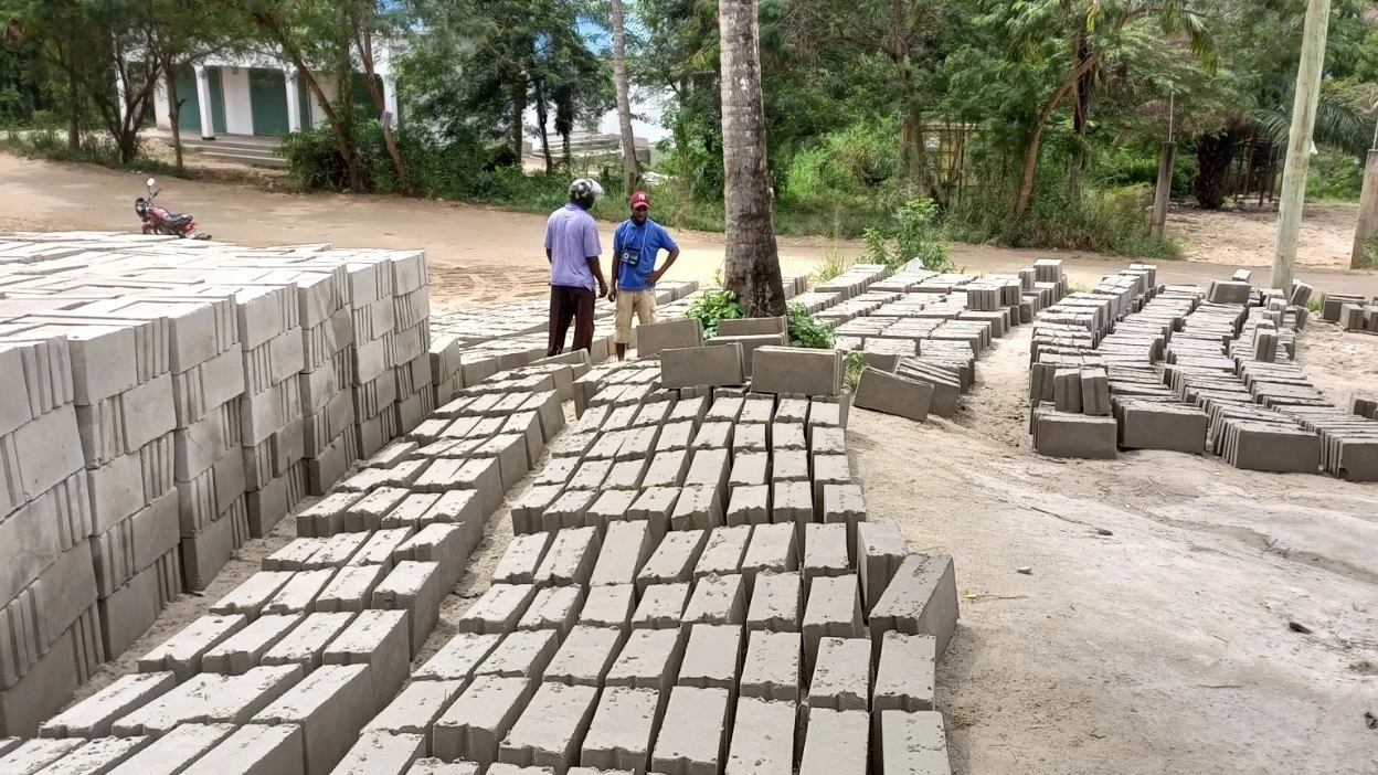 Iligas Nahoda, manager kwa mpemba vibrated blocks in Goba Dar es Salaam negotiates business with a concrete blocks customer. 