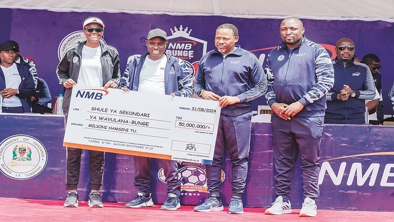 
Speaker of the National Assembly Dr. Tulia Ackson (L),  Deputy Prime Minister and Minister for Energy, Dr. Doto Biteko (2nd L), NMB Bank Chief Finance Officer, Juma Kimori (2nd R), display a dummy cheque donated by NMB bank.