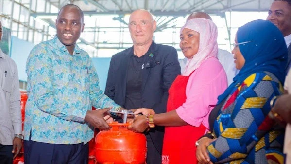 Deputy Prime Minister and Energy minister Dr Doto Biteko (L) presents a cooking gas cylinder to a Dar es Salaam food vendor yesterday. Looking on are the Minister of State in Vice President’s Office (Union and Environment), Dr Ashatu Kijaji (R).