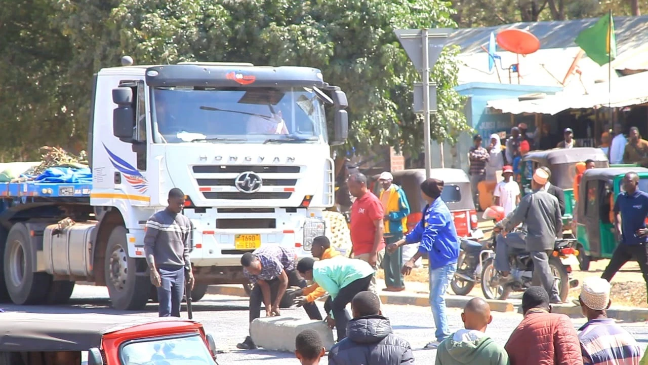 Wafanyabiashara wa mazao na makuli mkoani Singida wakiwa wamefunga barabara kuu ya Dodoma-Singida-Mwanza juzi eneo la uwanja wa mpira wa Liti mjini Singida wakipinga Mfumo wa Stakabadhi ghalani.