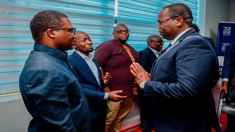 DCB Commercial Bank’s chief executive officer Sabasaba Moshingi (R), speaking with some of the bank's shareholders' representatives during the 22nd Annual General Meeting of the shareholders in Dar es Salaam yesterday.