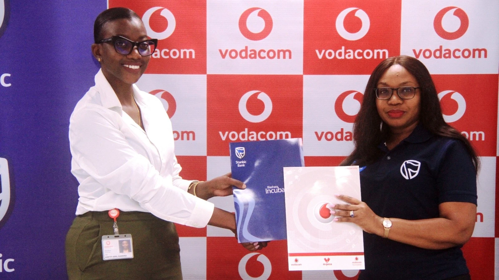 Mkuu wa Mahusiano ya Vyombo vya Habari Vodacom Tanzania,  Annette Kanora kushoto na Meneja wa Mahusiano na Chapa wa benki ya Stanbic Tanzania, Annette Nkini, wakibadilishana mikataba wakati wa kujiandaa na kampeni Twende Butiama.