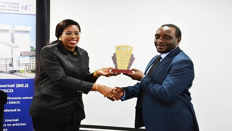 David Kafulila (R), Director of the Public-Private Partnership Centre, pictured in Dar es Salaam yesterday receiving a souvenir from College of Business Education rector Prof Edda Lwoga 