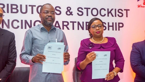 Leah Ayoub, business director at Equity Bank and Hussein Sufiani, director of communications at Bakhresa Group display documents after soon after signing a distributors and stockists financing partnership pact in Dar es Salaam on Thursday