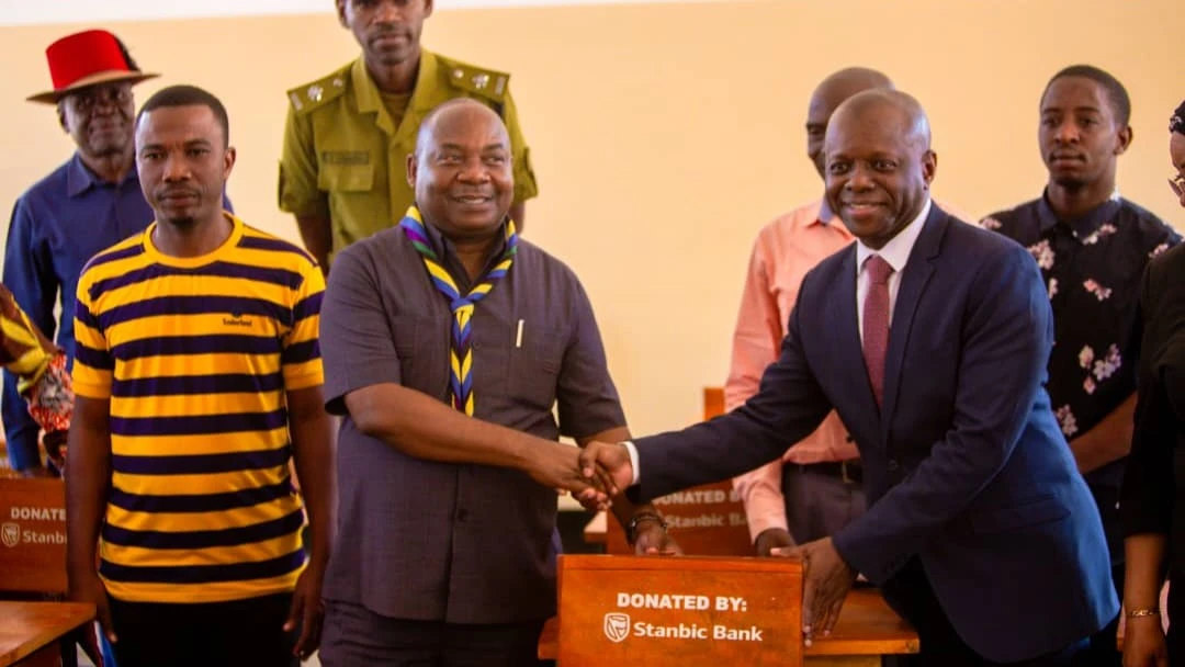 Bagamoyo, District Commissioner Shaibu Ndemanga (C), receives one of the desks from Stanbic Bank’s bank’s head of personal and private banking, Omary Mtiga for Kikaro Secondary School in Chalinze District Council recently