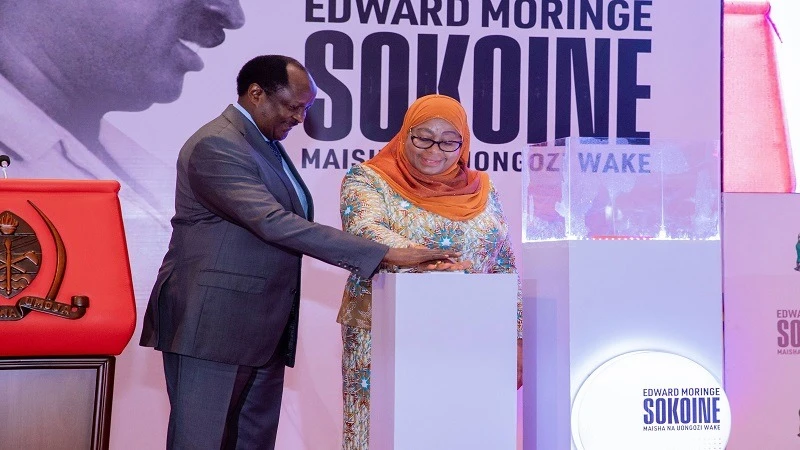 President Samia Suluhu Hassan and Ambassador Joseph Sokoine, one of Edward Moringe Sokoine’s sons, press a knob in Dar es Salaam yesterday in launching a book on the late former prime minister. 