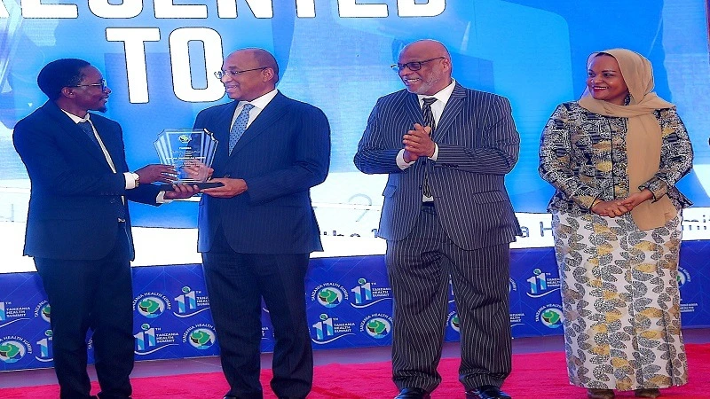 Dr Omar Chilo (L), founding president and chairman of the Tanzania Health Summit, presents an award to Zanzibar President Dr Hussein Ali Mwinyi in recognition of his contribution to the Tanzania’s health sector. 