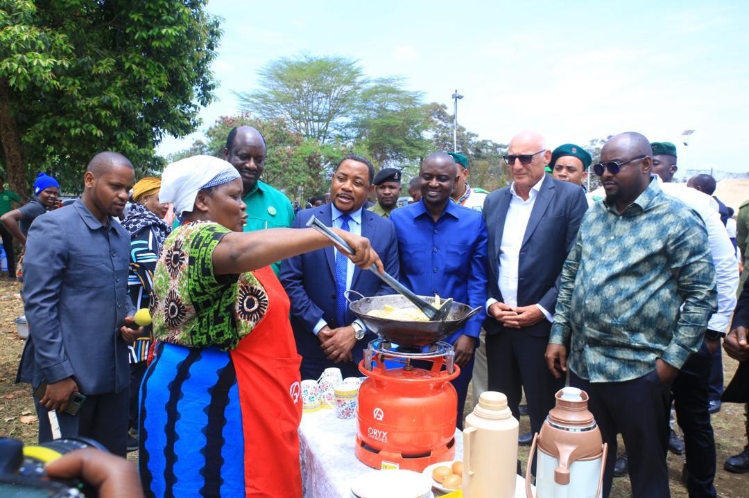 Education, Science, and Technology, Deputy Minister Omariy Kipanga (3rd L), Arusha Urban (MP), Mrisho Gambo (C), and Oryx Gas Tanzania Managing Director, Benoit Araman (2nd R), attentively watch one of the teachers from Arusha cooking using gas.