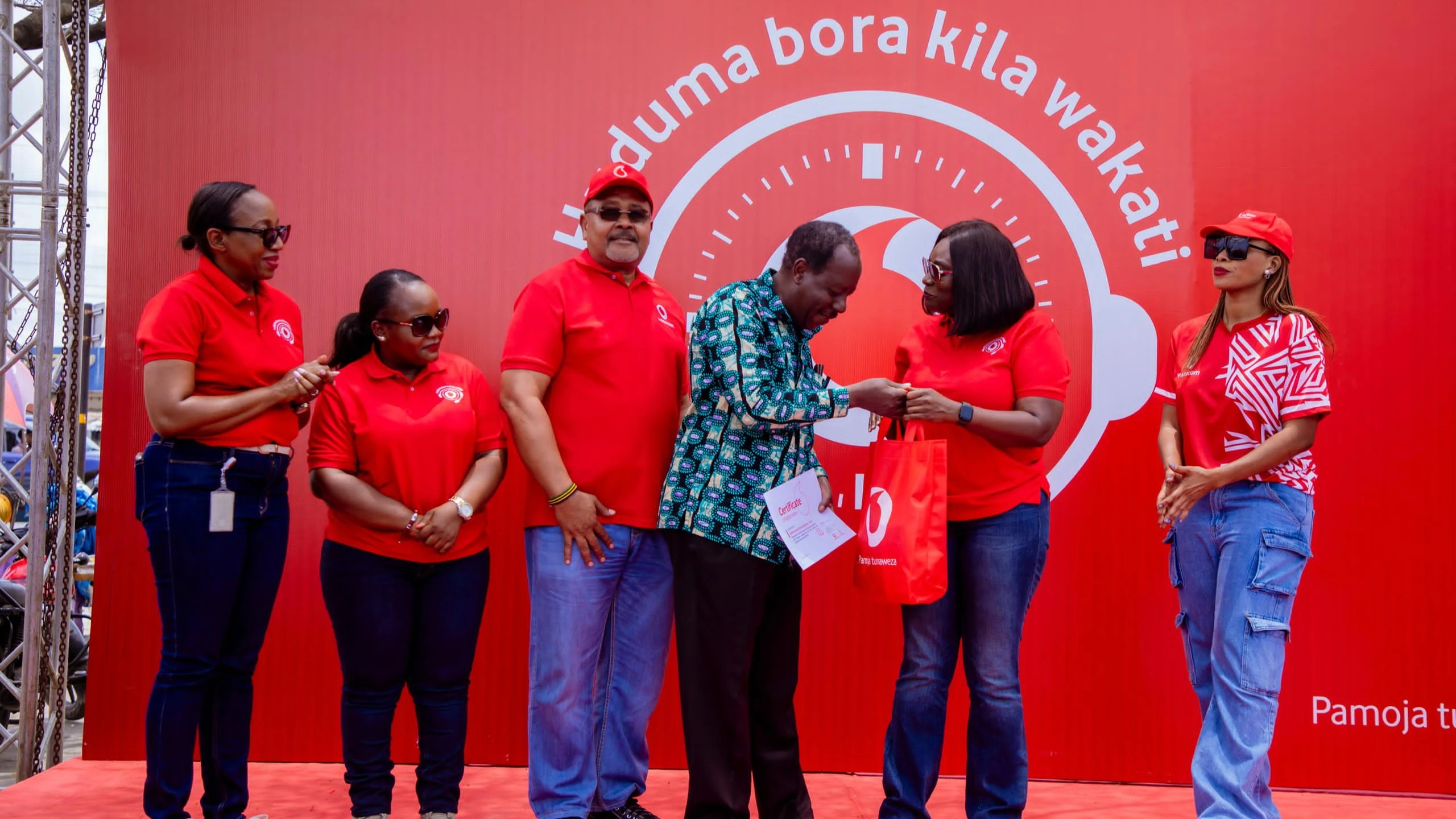 Mteja wa muda mrefu wa Vodacom Tanzania Plc, George Nyamugali (wa nne kutoka kushoto) akipokea zawadi kutoka kwa Mkurugenzi wa Huduma kwa Wateja, Harriet Lwakatare wakati wa maadhimisho ya Wiki ya Huduma kwa Wateja.