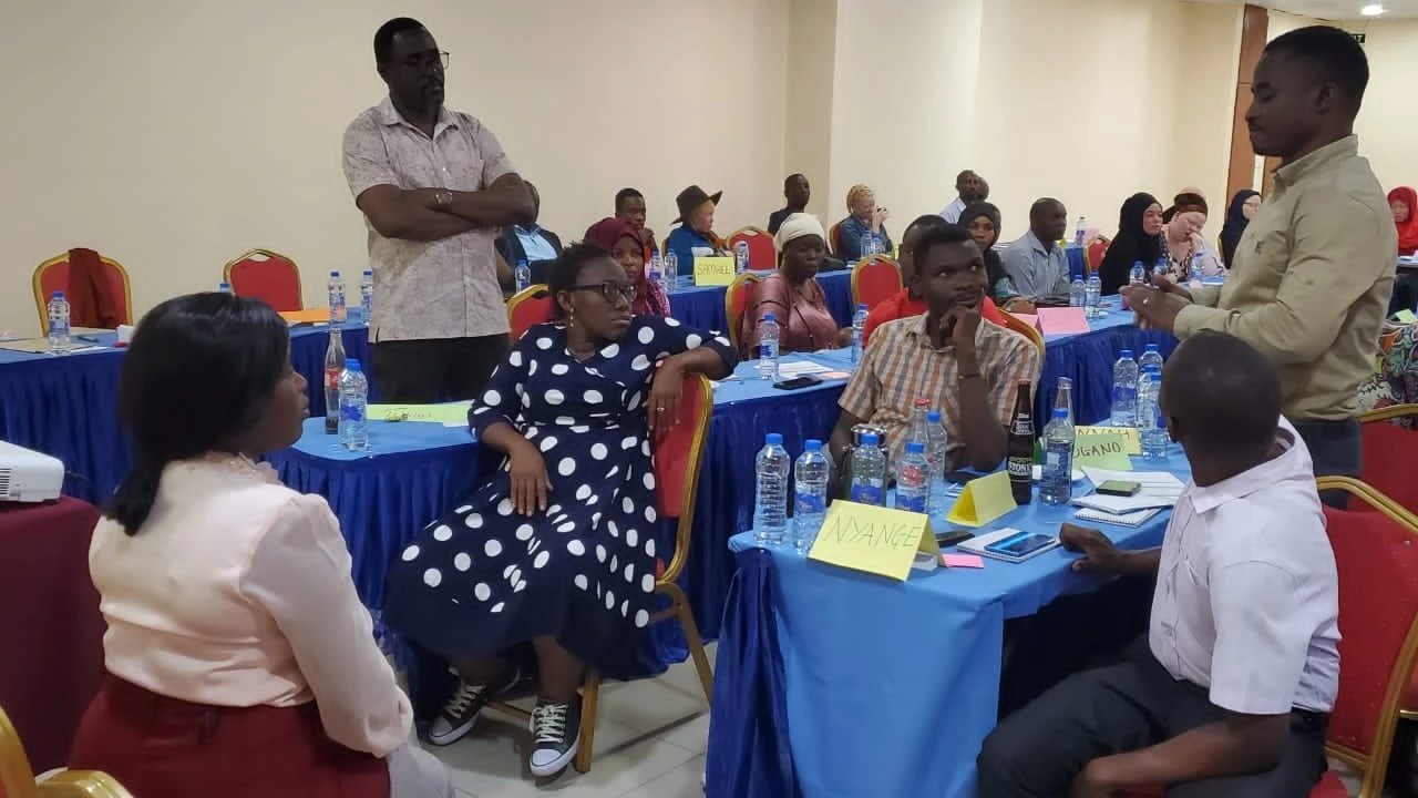 Disability inclusion expert, Francis Gugu standing far left, listens to one of the participants during a workshop for people with disabilities that was organized by Marie Stopes Tanzania in Dodoma recently