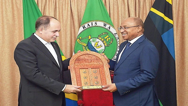 Zanzibar President Dr Hussein Ali Mwinyi gifts visiting Iranian Agriculture minister Dr Gholamreza Nouri (L) a Zanzibar carved door shortly after talks in Zanzibar yesterday. 