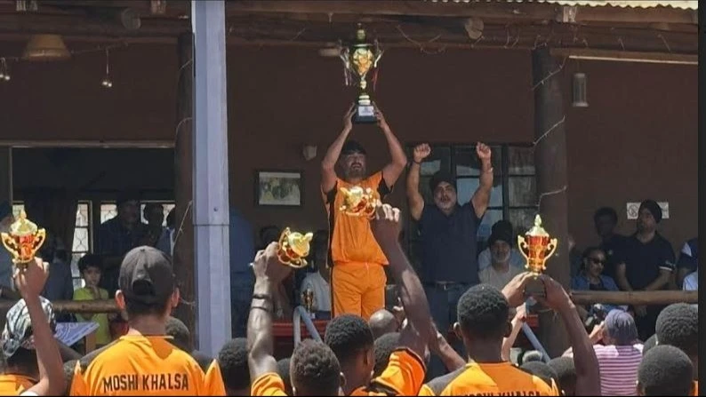 Kilimanjaro's Moshi Khalsa's captain, Varinder Bhamra, is pictured holding the trophy amidst cheers from teammates once the outfit won the 2024 Nyerere hockey tournament, beating Dar es Salaam's Black Mambaz in the final in Moshi last week.