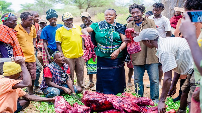 Manyara Regional Commissioner, Queen Sendiga (in Hadzabe ittire), distributes bush meat during her visit to the Yaeda Chini valley in Mongowamono village, Mbulu district, yesterday.