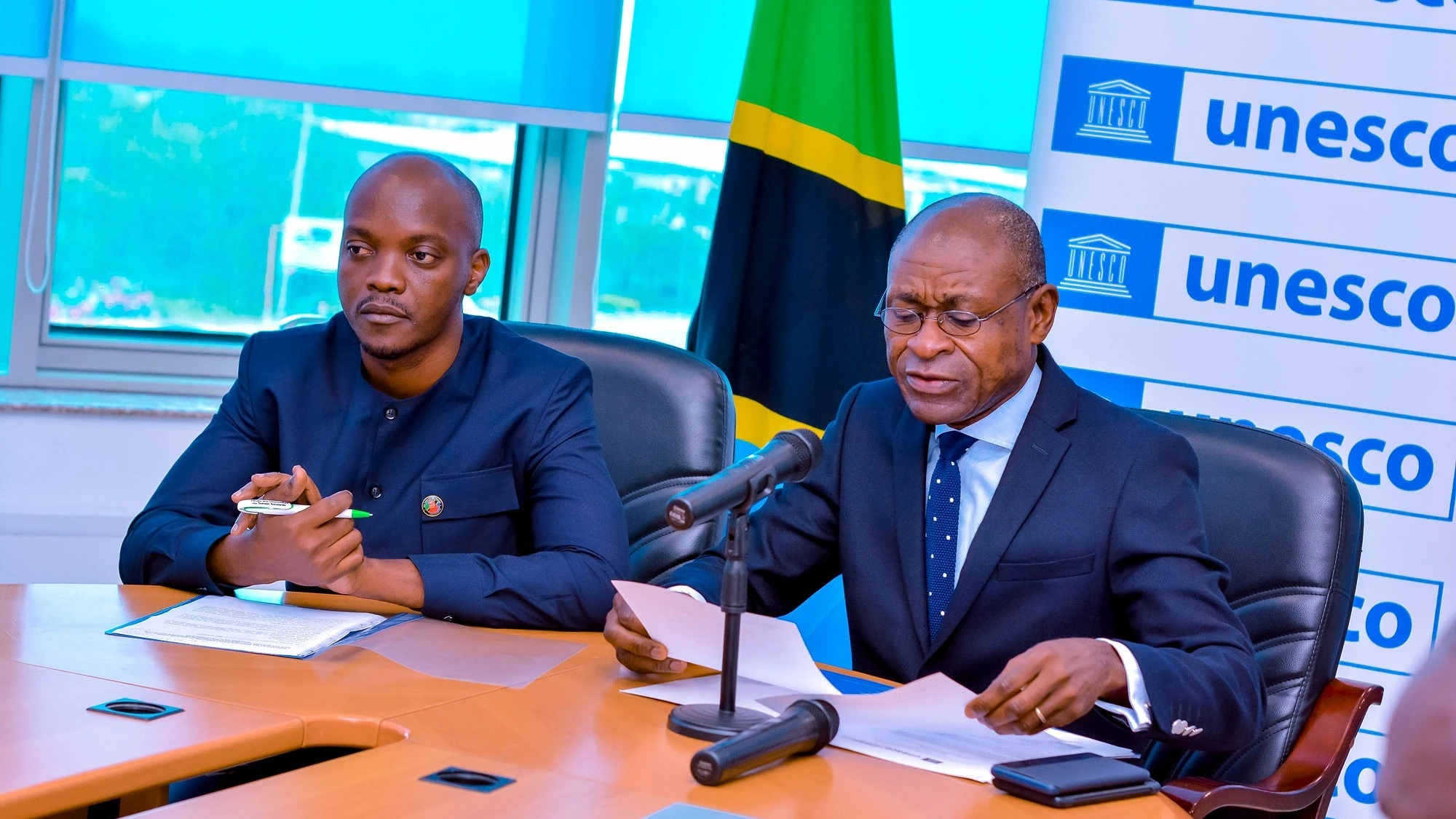 UNESCO Head of Office and Country Representative in Tanzania Michel Toto ( right) makes a speech during a hybrid kick off meeting to grantees of the UNESCO-Alwaleed Project in Tanzania.Flanking him is Boniface Kadili ,the Director of Culture in Tanzania.