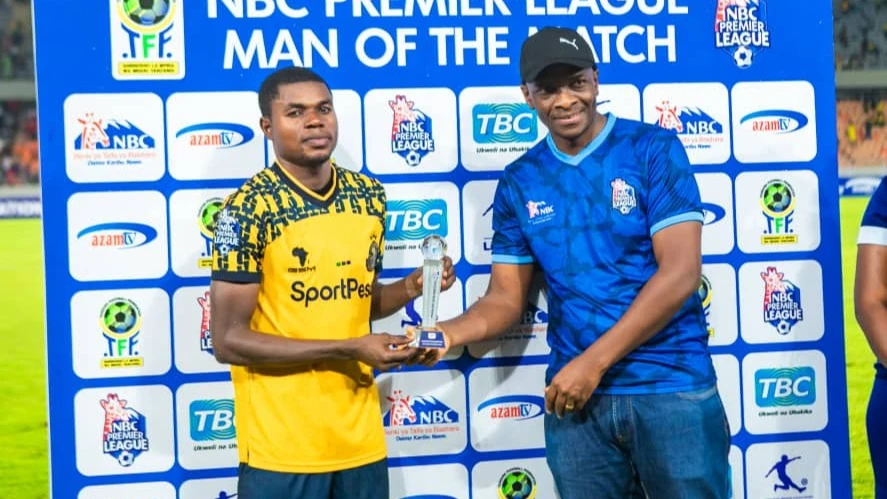 Mkurugenzi wa Fedha wa Benki ya NBC Rayson Foya (kulia) akikabidhi tuzo ya Mchezaji Bora (Man of the match) kwa mchezaji Maxi Nzengeli kutoka klabu ya Yanga SC aliyeibuka mchezaji bora wa mchezo kati ya Simba SC na Yanga SC maarufu kama ‘Kariakoo Derby.