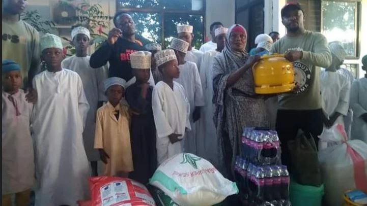 mari Clayton, the Advertisements and Production Director for Mafia Boxing Promotion (Front row, R), is pictured presenting a gas cylinder to Green Crescent Foundation's carer Zainati Saidi in Tanga recently. 