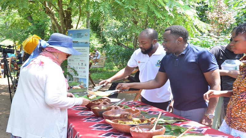   Zanzibar’s Tourism and Antiquities minister, Mudrik Ramadhan Soraga (in blue T-shirt) attends to a tourist at an event featuring organic foods derived from sustainable agriculture was held at the Msonge organic farm at Shakani in Zanzibar’s West Urban.