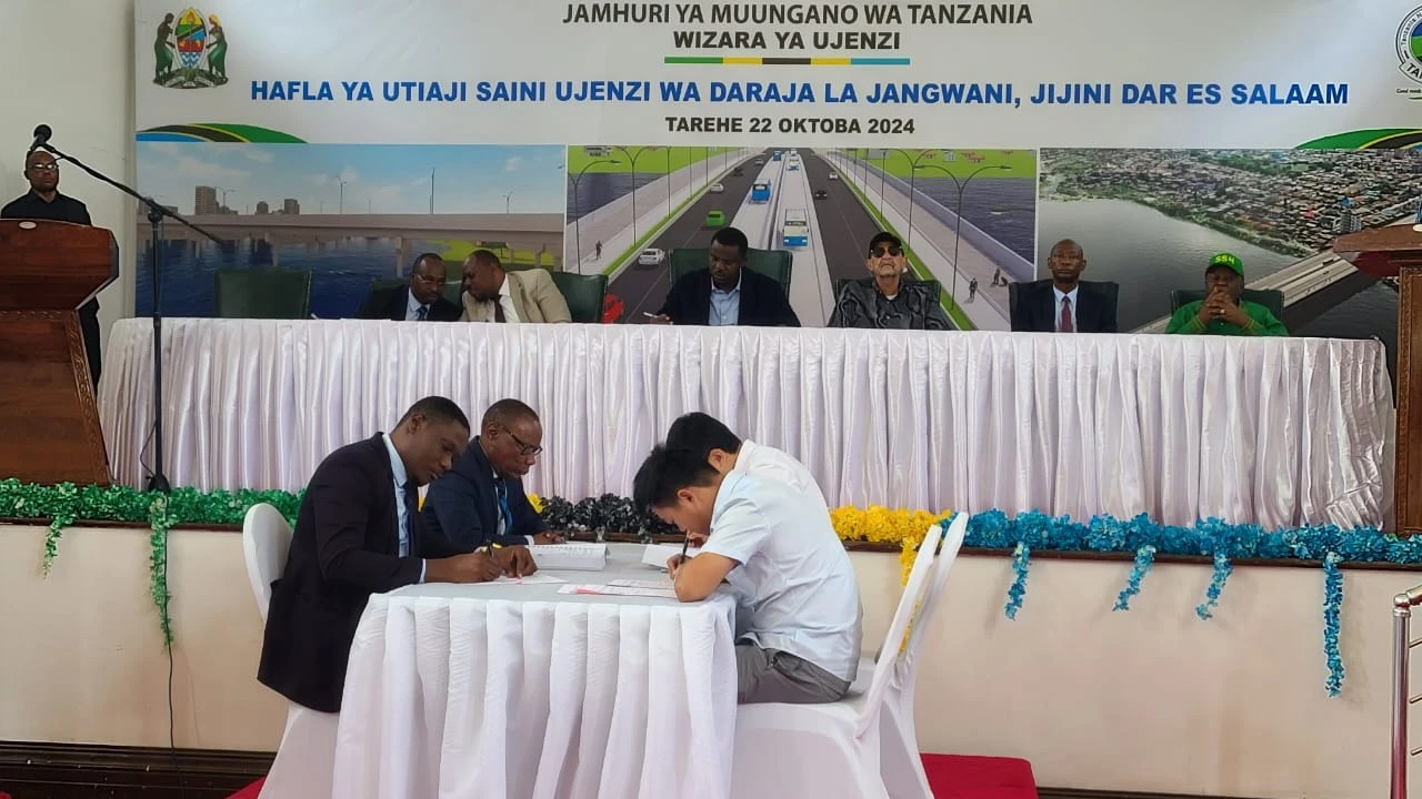 Mtendaji Mkuu wa Wakala wa Barabara Tanzania (TANROADS) Mohamed Besta, na wawakilishi wa Kampuni ya China Communications Construction Company Limited, wakisaini mkataba wa ujenzi daraja la Jangwani, leo.