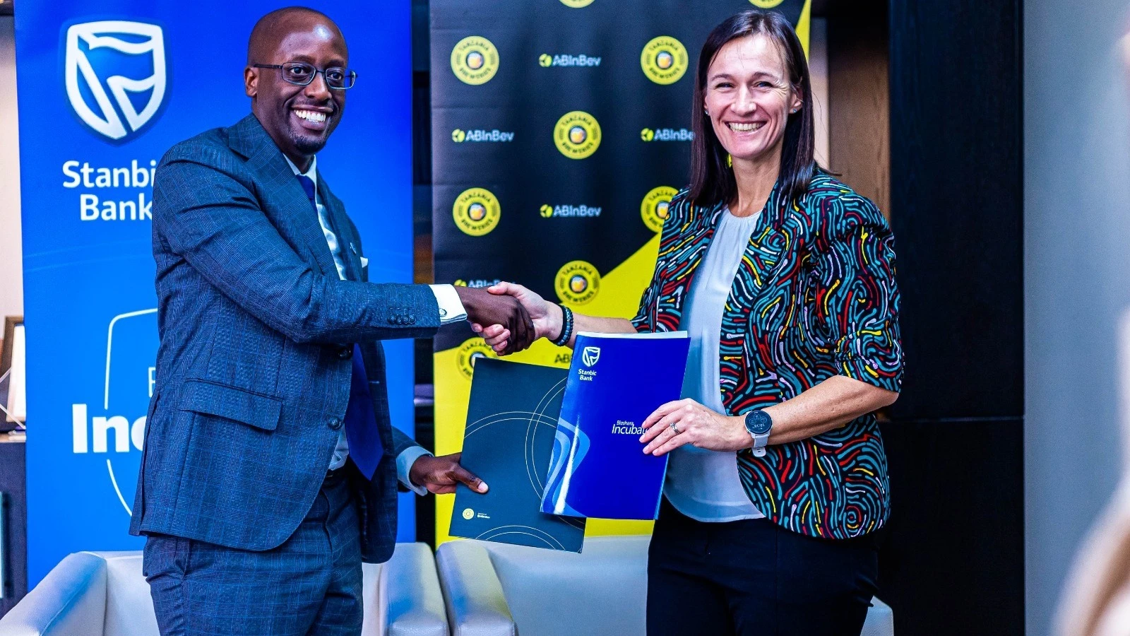 Michelle Kilpin, Managing Director of Tanzania Breweries Limited TBL (right) and Manzi Rwegasira, CEO of Stanbic Bank Tanzania, officially exchange signed documents, marking their partnership through a Memorandum of Understanding in Dar yesterday.