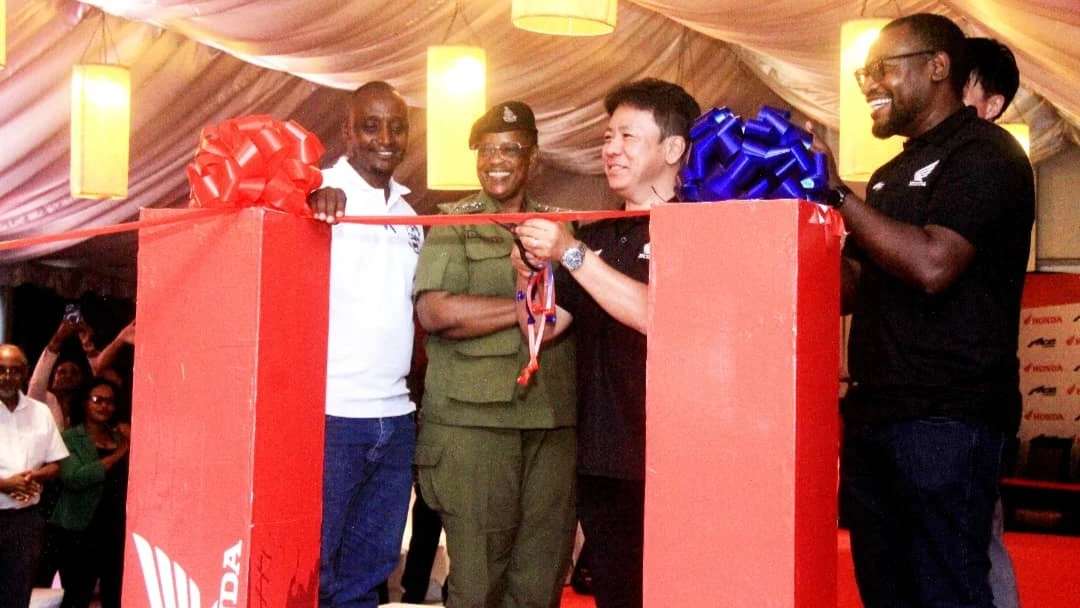 President and CEO of Honda South Africa Region, Hideki Shinjo (center) cutting the ribbon to officially launch the ACE 150 motorcycle in Dar es Salaam on Thursday.