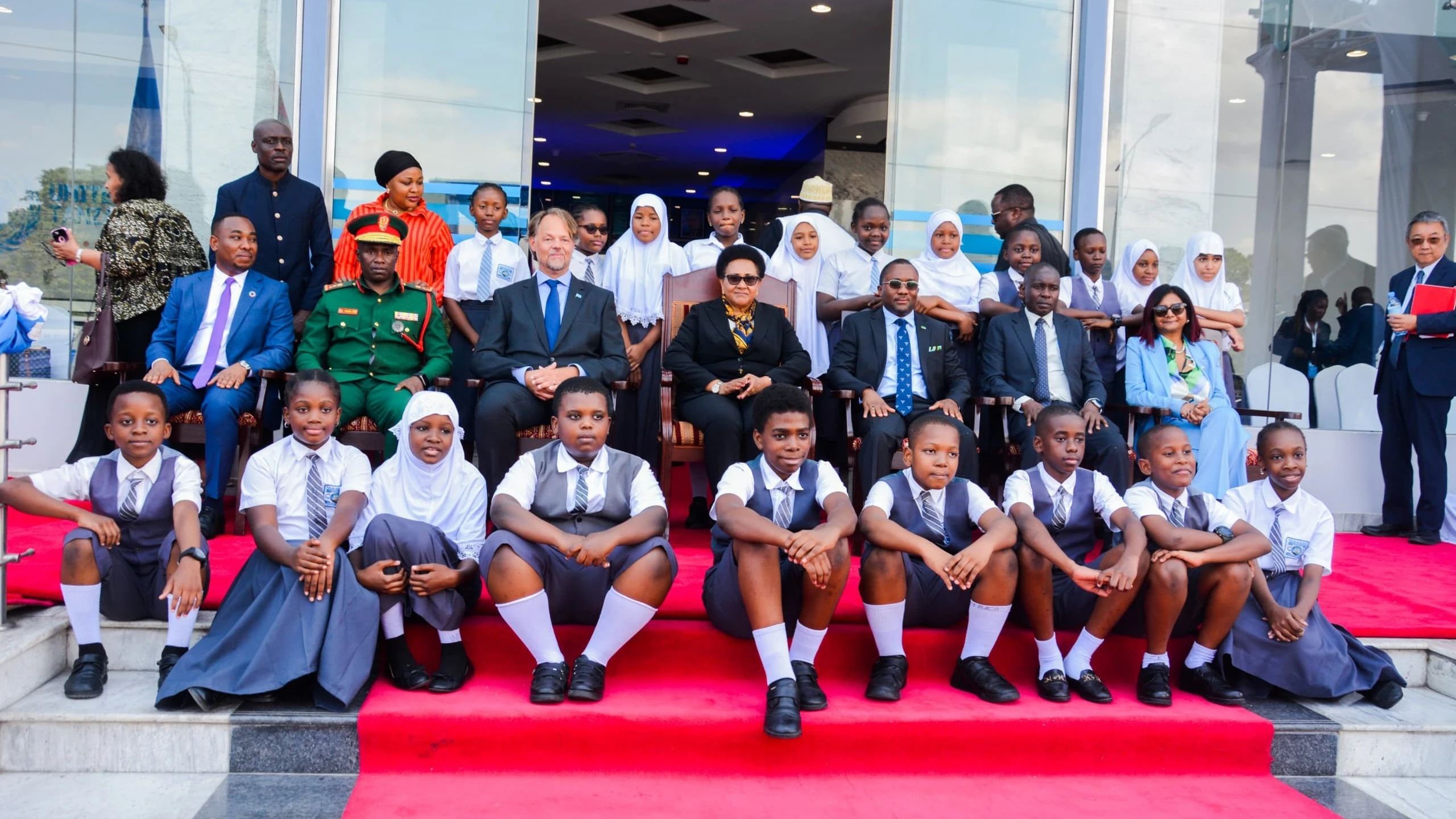 Dr Stergomena Tax, the Defense and National Service minister, (C) UN attaches and students pictured during the flag raising ceremony to mark the 79th anniversary of UN founding