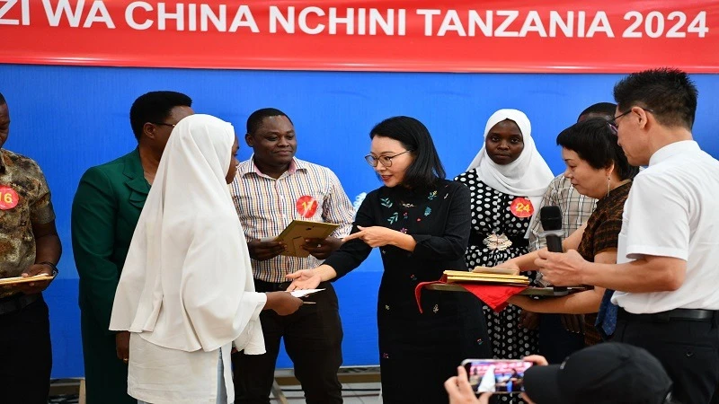 China’s Ambassador to Tanzania, Chen Mingjian, (C), pictured in Dar es Salaam at the weekend recognising a student of the city’s Zanaki Secondary School chosen into a group of 132 students &teachers to get 2024's edition of the Chinese Ambassador’ Award.