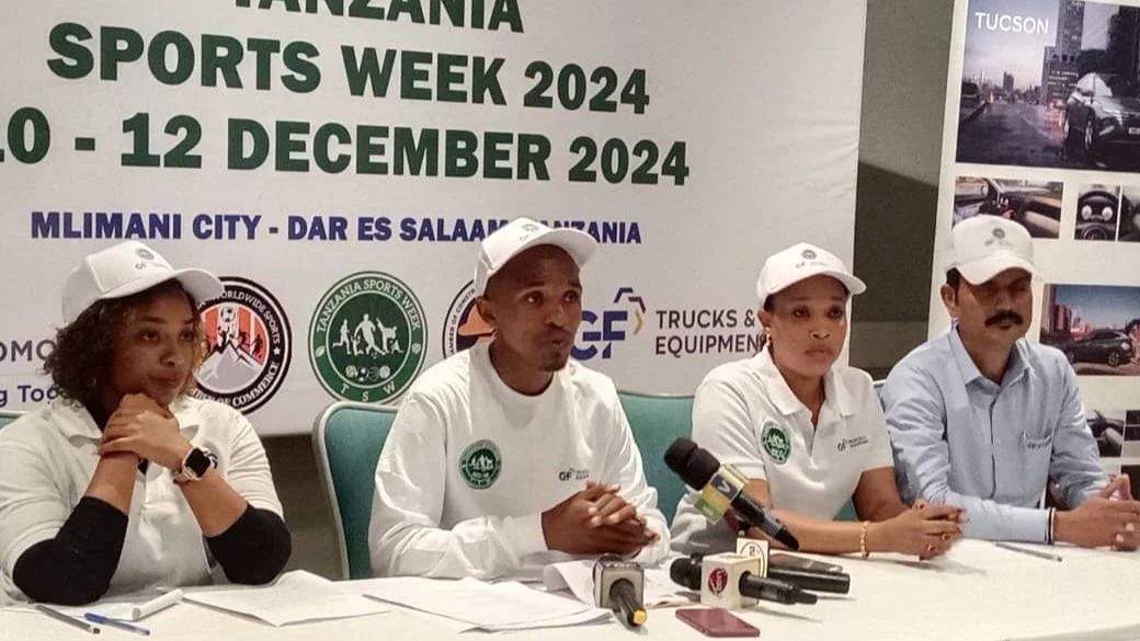 Tanzania Worldwide Sports Chamber of Commerce (TWSCC) President Steven Mkomwa (center) briefs journalists on the upcoming Tanzania Sports Week (TSW). To his left is Dianarose Mboya, Marketing Officer from GF Trucks. 