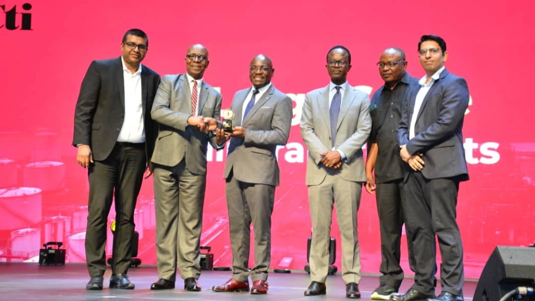 Deputy Minister Exaud Kigahe presents a trophy to KIOO Limited’s HR Manager, Jacob Msuya, for winning the Mineral Sector award in the President's Manufacturer of the Year Awards (PMAYA), organized by the Confederation of Tanzania Industries (CTI). 