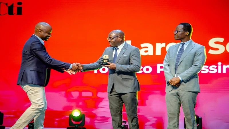  Deputy Minister of Industry and Trade Exaud Kigahe (C )  presents an award to Alliance One spokesperson John Magoti (L), during the t industrial manufacturers award held last weekend. Right is the (CTI) Chairman Paul Makanza.