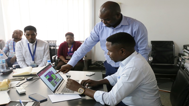 Tanzania Media Foundation executive director Dastan Kamanzi (standing) demonstrates to The Guardian Ltd deputy general manager Jackson Paul at the newspaper publishing firm’s offices in Dar es Salaam yesterday