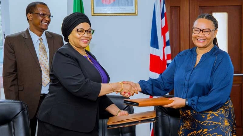 Dr Natu El-Maamry Mwamba (L), Permanent Secretary in the Finance ministry, exchanges documents in Dar es Salaam yesterday with Kemi Williams, Director for Development at the British High Commission in Tanzania.