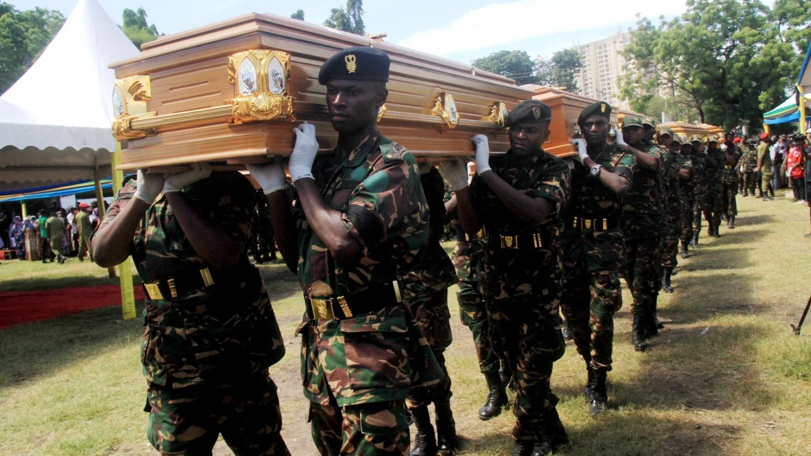 Tanzania People’s Defence Forces officers pictured in Dar es Salaam yesterday carrying the caskets bearing the bodies of some of the people who died in Saturday’s collapse of a multi-floor building in the city’s sprawling Kariakoo market zone. 