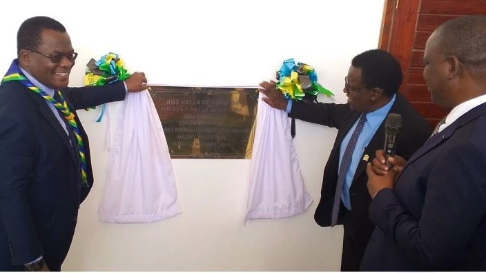 Dr. Charles Mwamwaja, the Commissioner of Financial Sector Development, ministry of finance (L) opens a curtail to inaugurates the new Institute of Rural Development Planning (IRDP) campus at Miyuji. 