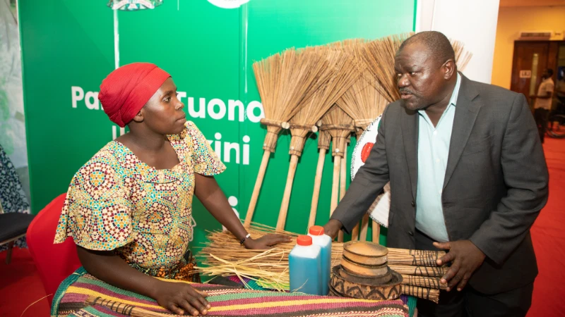 Mkurugenzi wa Miradi wa TASAF akiongea na mlengwa katika banda la TASAF katika kuadhimisha siku ya watu wenye Ulemavu duniani yaliyofanyika katika Ukumbi wa diamond jubilee Jijini Dar es Salaam