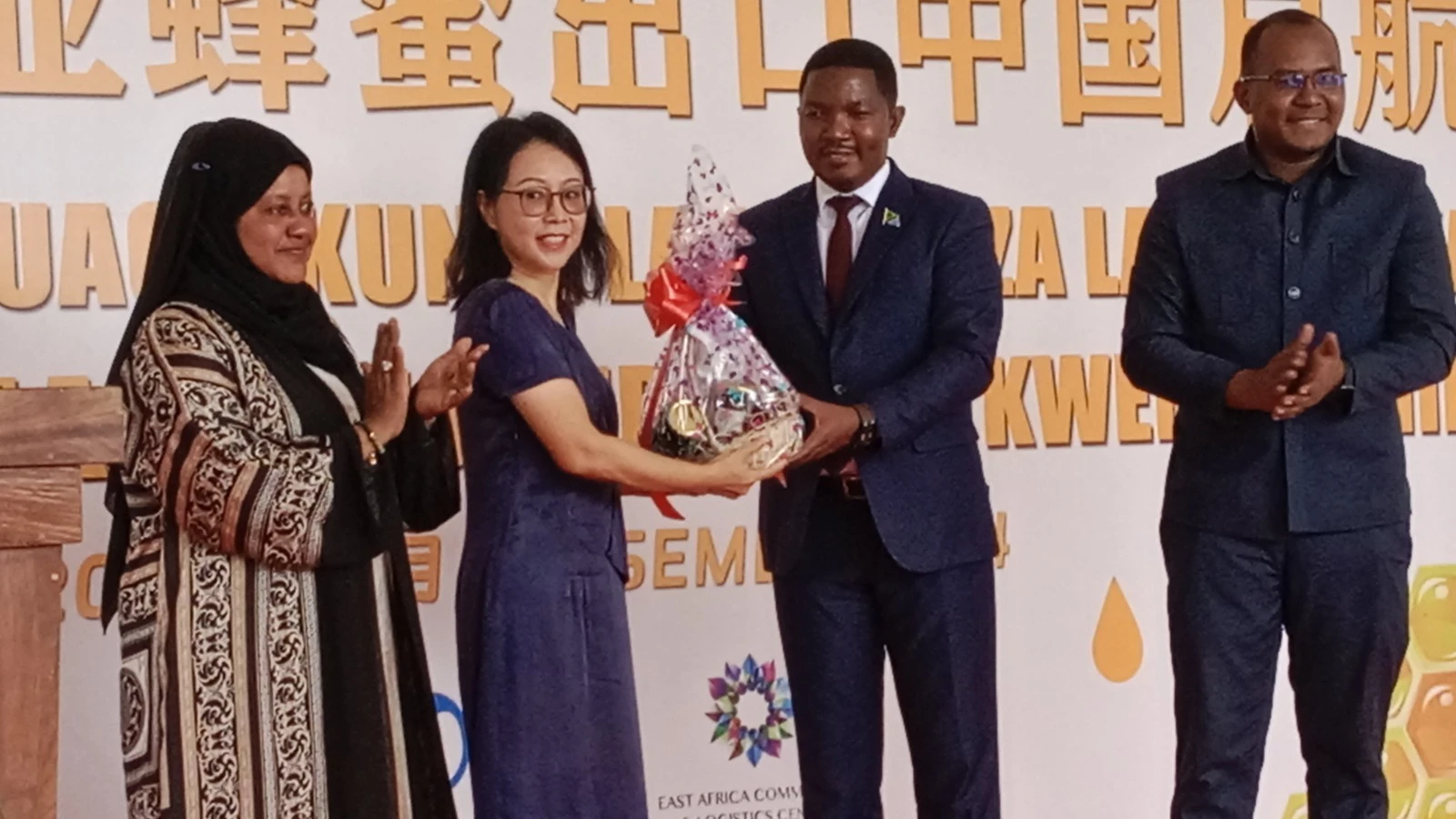 Chinese Ambassador Chen Mingjian (left) receives honey from the Industry and Trade Minister Dr. Suleiman Jaffo (right) as a token of appreciation, alongside TANTRADE Director General Latifa Hamis(L) and  Karim Solyambingu (R) representing TFS.