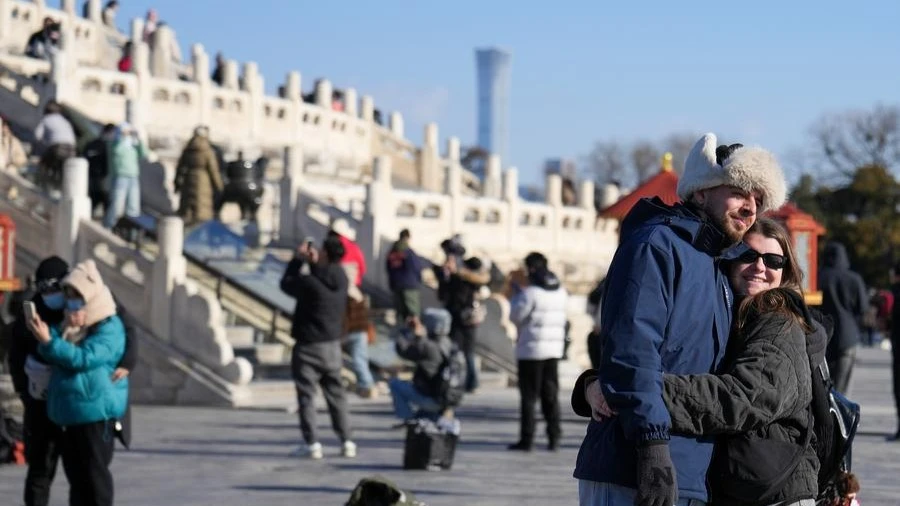 Foreign tourists pose for photos at Tiantan (Temple of Heaven) Park in Beijing, capital of China, Dec. 5, 2024.