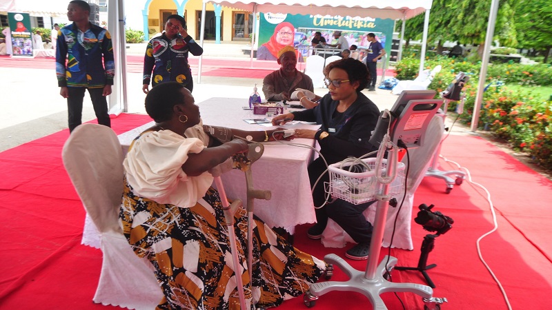 Fatma Suedy (R), a nursing officer with Dar es Salaam’s Jakaya Kikwete Cardiac Institute, pictured in the city yesterday attending to a person with disability seeking medical attention