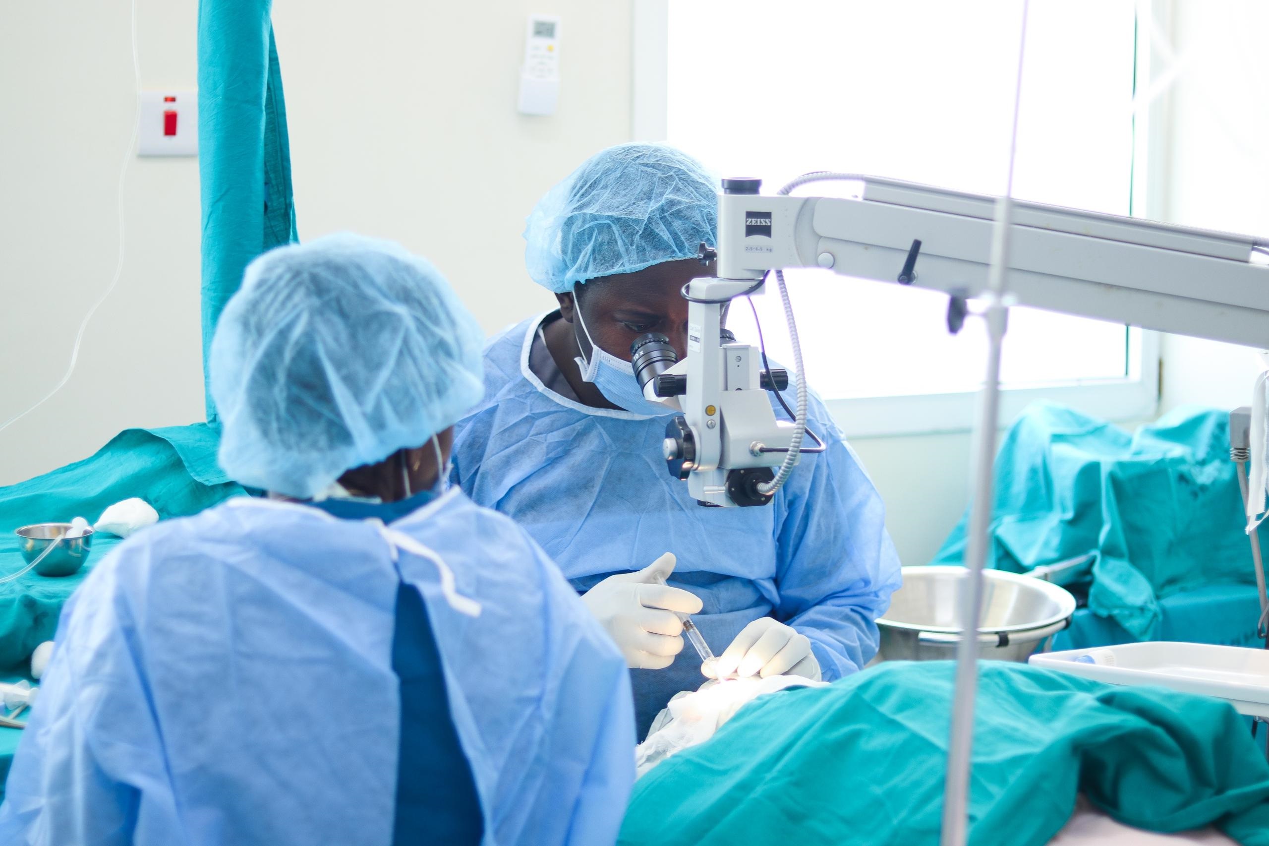 Dr Rogers Sempinduna (R), a Muhimbili National Hospital ophthalmologist (eye care specialist), pictured on Monday performing cataract surgery at St. Joseph’s Mission Hospital Peramiho on one of several people lined up for the operation. 