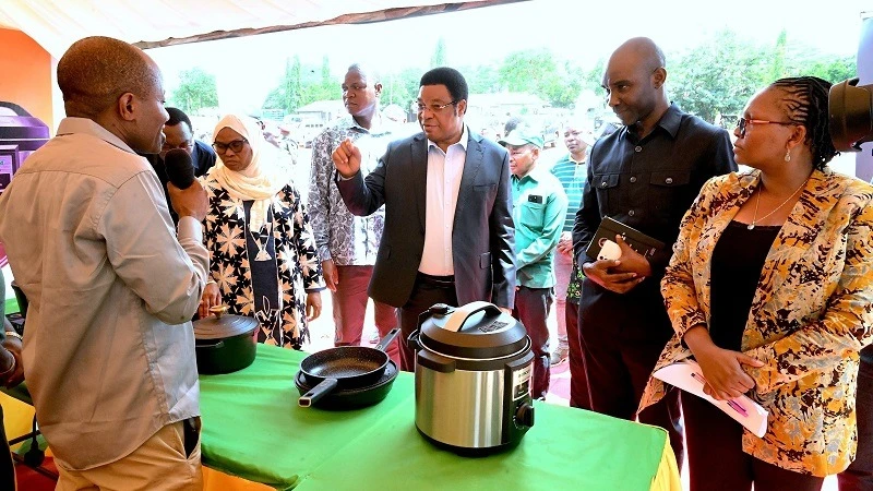 Prime Minister Kassim Majaliwa listens to Hope Mahokola (L), the marketing officer of the National Mining Corporation (STAMICO), who  briefed him about the energy-efficient stoves at the STAMICO exhibition booth. The event was held at   Azimio  Kizimkazi 